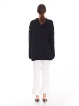Buzo oversized color negro con cuello subido tipo polerita y pequeños cortes laterales, fabricado en 100% algodón.