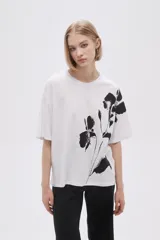 Remera blanca de corte holgado con estampado de flores negras.