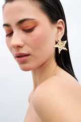 Aros colgantes con forma de estrella dorada con textura irregular.