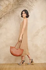 Vestido midi color beige de lino, corte amplio, sin mangas y con bolsillos laterales.