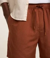 Bermuda de baño masculina confeccionada en tejido ana ruga texturizado, con lazo en la cintura, bolsillos laterales y un bolsillo trasero.