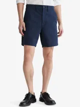 Short de vestir azul marino, de corte recto, con bolsillos laterales y traseros. Se ajusta a la cintura con cinturón de cuero marrón.