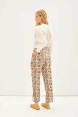 Pantalón babucha de voile de algodón con estampado floral en tonos ocre y marrón. Tiene lazos internos en el ruedo para ajustar el largo.