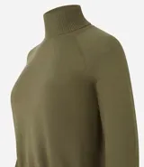 Blusa de punto color blanco, con cuello alto, manga larga y diseño liso.