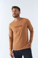Remera color ocre de manga larga con cuello redondo y logo estampado en el pecho.