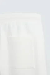 Bermuda color arena de tejido interlock de algodón con elasticidad, corte relaxed fit, cintura elástica ajustable con cordón interior, bolsillos laterales y bolsillo trasero de plastrón.