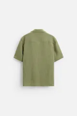 Camisa verde oliva de manga corta con cuello bowling, corte relaxed fit y cierre frontal con botones.