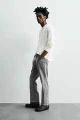 Pantalón de jean celeste de corte flare, con cinco bolsillos, efecto lavado y bajo con acabado irregular.