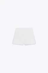 Shorts blancos de tiro alto con cremallera lateral oculta en la costura.