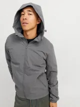 Campera gris con capucha ajustable con cordón, cierre frontal con cremallera, bolsillos delanteros con cierre y puños de canalé.