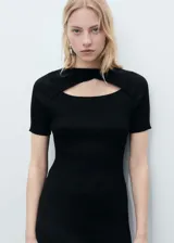 Vestido midi negro de punto, entallado, con cuello redondo, mangas cortas y abertura en la parte delantera. Diseño reversible.