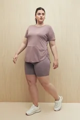 Remera deportiva color lila de manga corta con calce relajado y corte horizontal en la parte inferior.