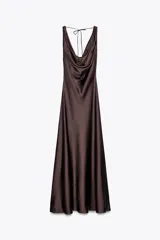 Vestido largo marrón satinado con escote pico fluido y tirantes anchos. Espalda descubierta ajustable con cordones y bajo asimétrico evasé.