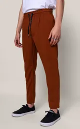 Pantalón de jogging color marrón con corte recto, bolsillos laterales, cintura elástica y cordón de ajuste.