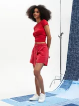 Short pollera color rojo con cierre frontal con botones y ruedo desflecado.