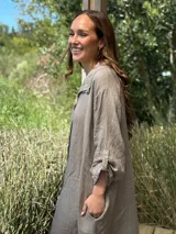 Vestido camisero amplio y largo de lino color azul, con botones de nácar, cuello camisero y bolsillos laterales.