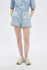 Short celeste de jean con cintura elastizada y cordón ajustable. Presenta apliques de strass plateados.