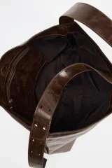 Bolso shopper marrón de efecto acharolado con asa de hombro ajustable, bolsillo interior con cremallera y cierre magnético.