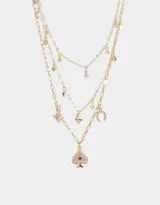 Collar dorado multicadena con dijes de strass con motivos de suerte: herradura, trébol, carta y dado.