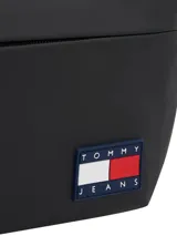 Riñonera negra de poliuretano con logo engomado de Tommy Jeans en el frente. Tiene correa ajustable con hebilla y compartimento principal con cierre.