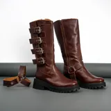 Bota alta de cuero vacuno color negro, con suela de goma artesanal, cierre interno YKK, hebillas ajustables y estribo desmontable.