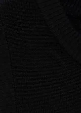 Vestido negro de punto fino, largo hasta la rodilla, sin mangas y cuello redondo.