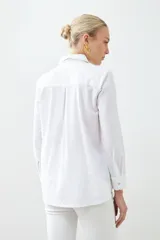 Camisa blanca de manga larga con cuello clásico y cierre frontal con botones.