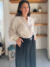 Pantalón palazzo negro de satén con lazo en la cintura.