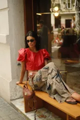 Top corto de cuero rojo con cuello redondo y mangas cortas abullonadas.