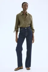 Camisa verde militar de lino liviano con cuello, botones adelante y canesú de doble capa en la espalda. Modelo con hombros apenas caídos, mangas largas con puños abotonados, bolsillo superior de parche y bajo levemente redondeado.