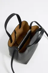 Bolso de mano negro Bimba y Lola modelo Chihuahua S, fabricado en piel regenerada con piezas de metal. Cuenta con asa regulable de piel, cierre con cinta de piel, logo metálico BIMBA Y LOLA, acabados metálicos, bolsillo interior con cierre de cremallera e interior con logo grabado.