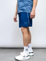 Short deportivo negro de entrenamiento, marca Umbro, con logo estampado en la pierna izquierda y detalles laterales con repetición del logo. Confeccionado en tejido elástico de cuatro direcciones.