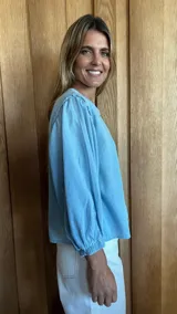 Camisa de mangas largas abullonadas con puños elásticos, cuello redondo y cierre frontal con botones.