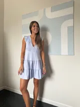 Vestido corto lila con escote en V, volados en los hombros y falda con dos niveles de volados.