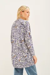 Saco tipo cardigan abierto con estampado animal print en tonos blanco, azul y dorado. Posee bordados de lentejuelas.