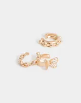 Set de tres cuffs dorados para la oreja con diferentes diseños: uno con forma de cadena, otro con forma de moño y otro con pequeñas esferas.
