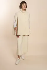 Capa color crema de lana con cuello alto y abotonadura lateral.