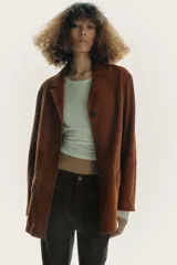 Blazer de cuero color marrón, con cuello solapa de muescas y manga larga. Tiene bolsillos con solapa en delantero, forro interior y cierre frontal con botones.