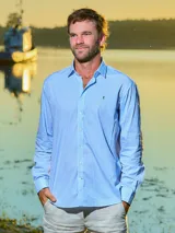 Camisa de hombre de manga larga, corte clásico, con cuello italiano y estampado a cuadros en tonos celeste y blanco.