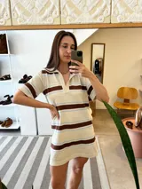 Vestido corto tejido de algodón color crema, con cuello polo, mangas cortas y rayas horizontales marrones y celestes.