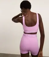 Top deportivo azul con breteles anchos, copas desmontables, recorte en el busto y banda elástica inferior color borgoña con letras blancas.