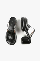 Mule color caramelo con plataforma y taco cilíndrico, tira superior negra y puntera cuadrada.