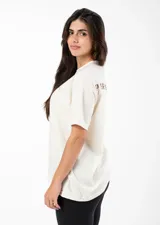 Remera color crudo de algodón con estampado serigráfico en la espalda con la palabra 'PERSISTENCE'.