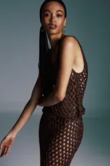 Blusa corta de punto calado color marrón con hilo metálico, cuello redondo y sin mangas.