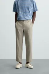 Pantalón de vestir azul marino confeccionado en tejido de lino. Corte recto, con bolsillos laterales y traseros. Se ajusta a la cintura con botón y cremallera.