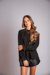 Camisa color crema con cuello alto y mangas largas con volados en los puños. Presenta detalles de crochet y broderie en el frente.