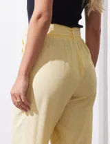 Pantalón de lino color amarillo con pretina ancha, pasadores y lazo de ajuste.
