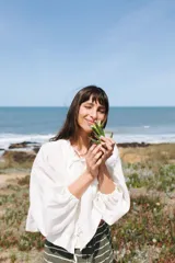 Blusa negra de lino con mangas balloon, largo a la cadera, cuello a la base y cierre con tiras.