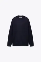 Jersey de punto azul marino confeccionado en 100% lana, de corte recto, con cuello redondo y mangas largas.