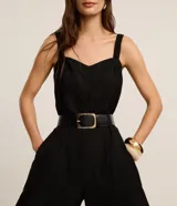 Mono de mujer color rojo oscuro (bordó), de corte recto y pierna ancha, con escote corazón y tirantes anchos con elástico. Presenta pliegues frontales que caen rectos hasta el ruedo.